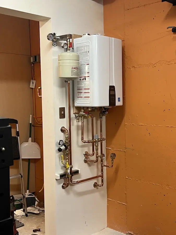 Plumbing technician inspecting water heater connections in Falls Church